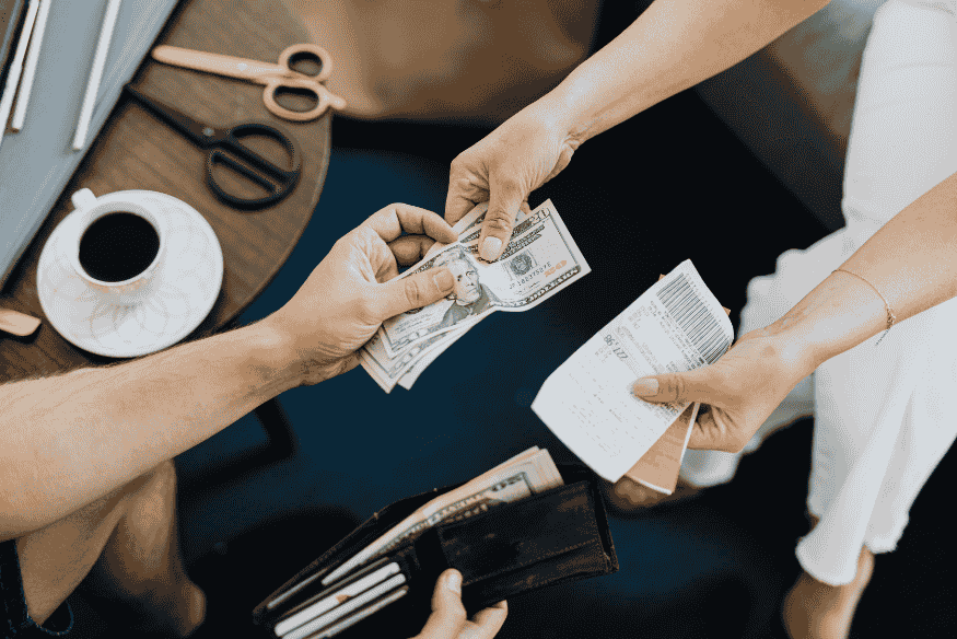 Pessoa entregando dinheiro em espécie junto a um recibo, simbolizando a negociação de um acordo de dívida com condições flexíveis de pagamento.