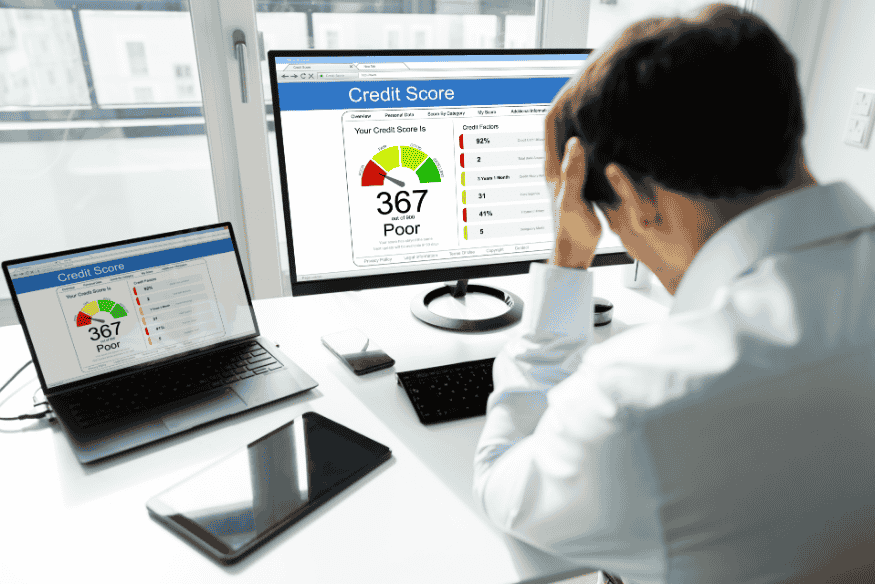 Pessoa preocupada observando o score de crédito baixo em seu computador, simbolizando o impacto negativo dos atrasos de pagamento no score.