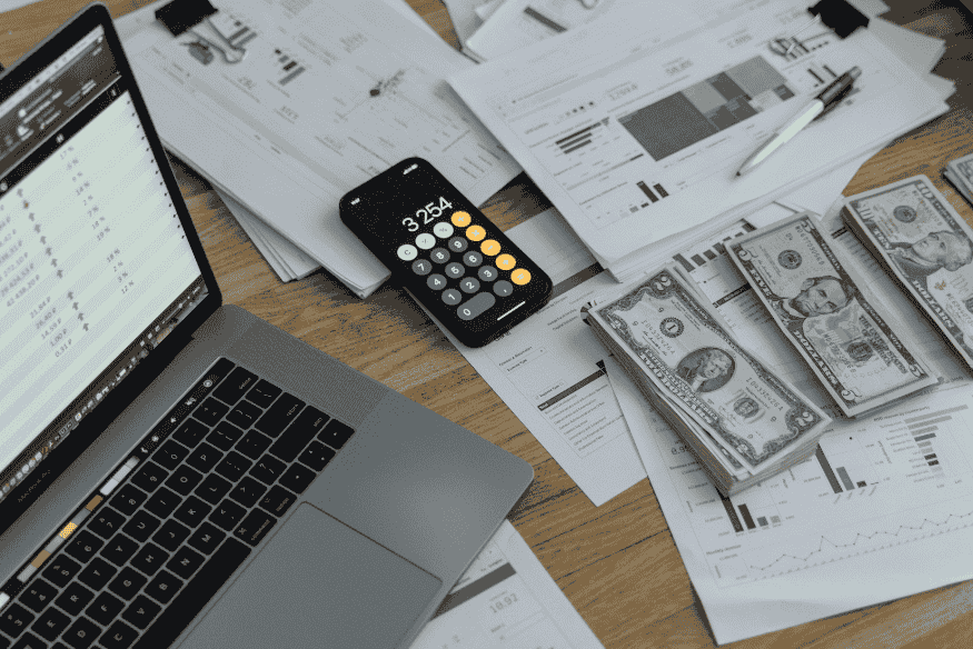 Gestão financeira com gráficos, dinheiro e calculadora representando o cartão de crédito consignado como ferramenta estratégica