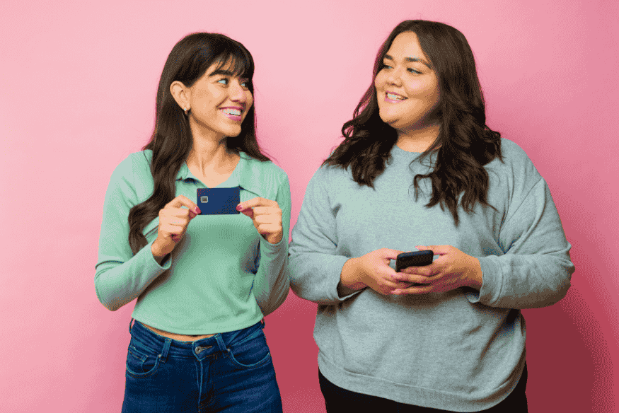 Duas mulheres felizes discutindo sobre cartão de crédito sem anuidade, representando a escolha do melhor cartão recentemente
