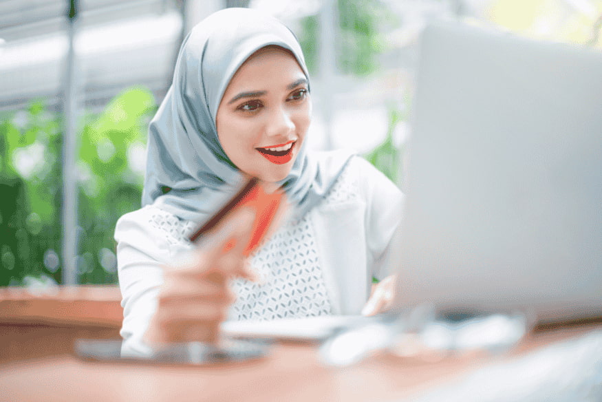 Mulher usando cartão de crédito sem anuidade para compras online com benefícios de cashback, pontos e milhas