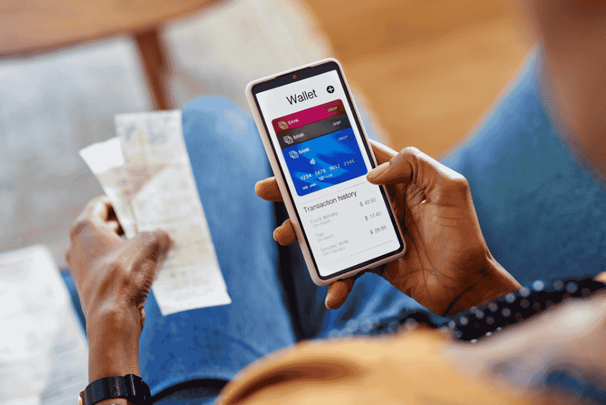 Uso de carteira digital em smartphone mostrando cartões virtuais para maior segurança em pagamentos online