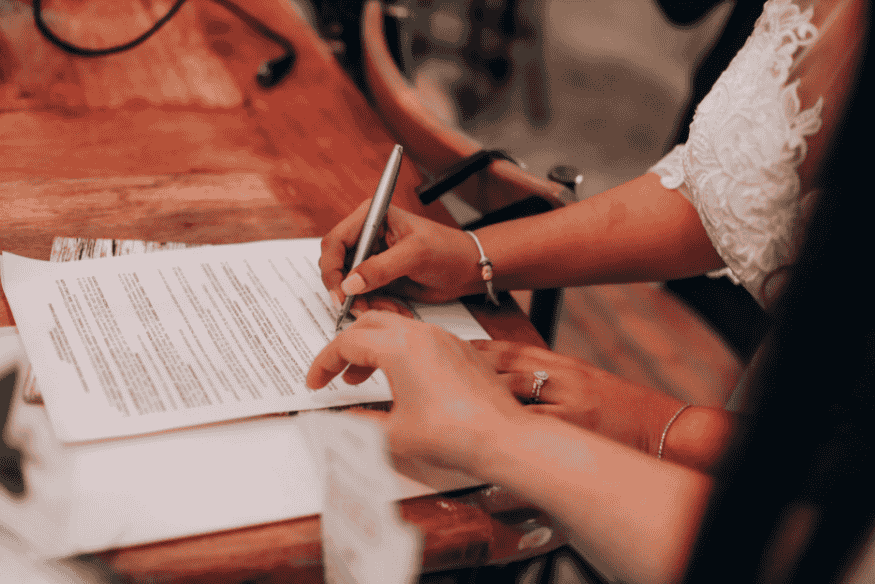 Pessoa assinando documento oficial para registrar uma reclamação por cobrança indevida, assegurando validade jurídica à denúncia.