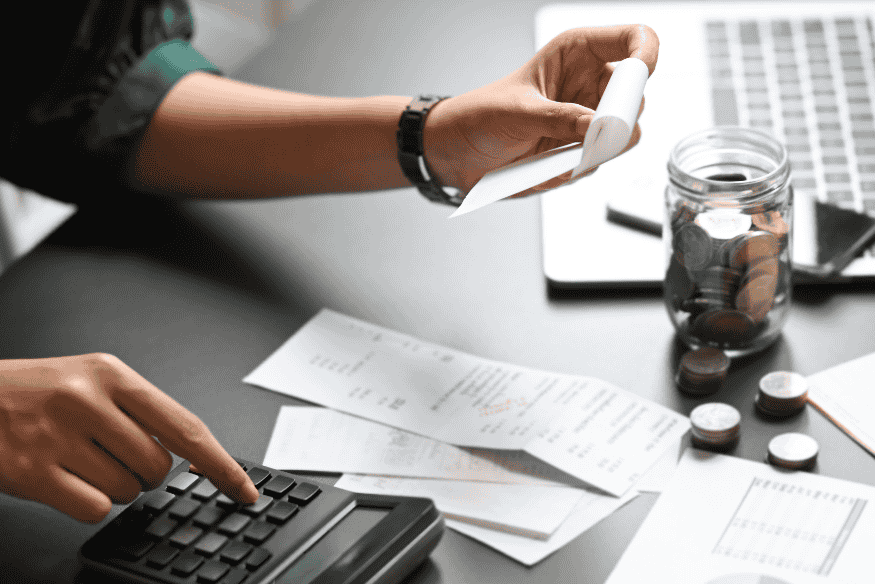 Pessoa calculando despesas e organizando contas para manter o nome limpo e movimentar a conta bancária