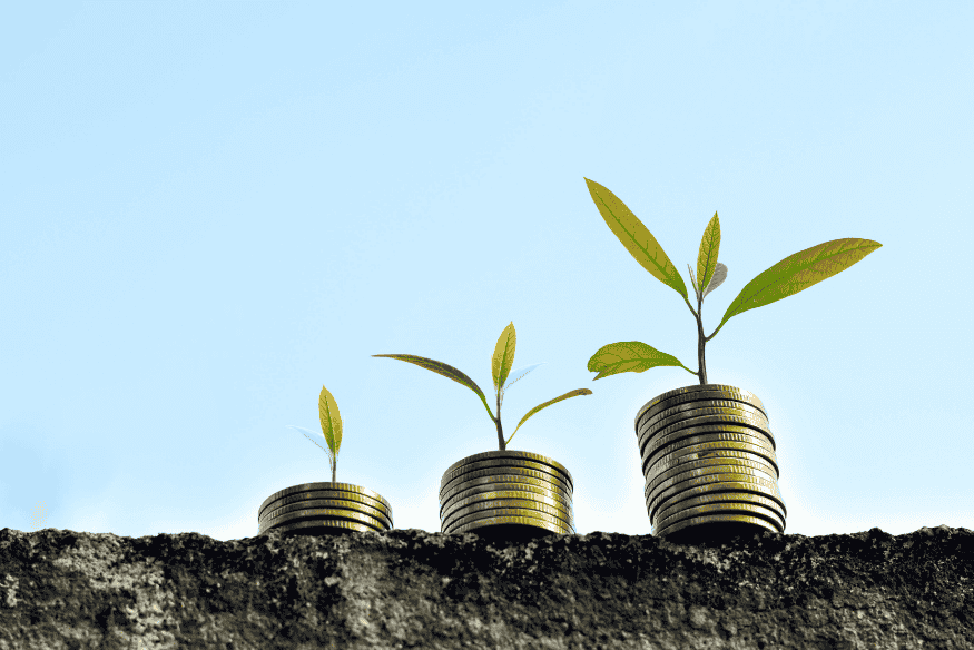 Três pilhas de moedas com plantas crescendo, simbolizando o crescimento financeiro e a reconstrução gradual do crédito após quitar dívidas.