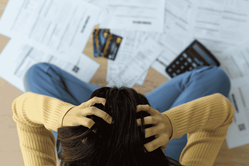 Pessoa preocupada com dívidas de cartão de crédito acumuladas no crédito rotativo