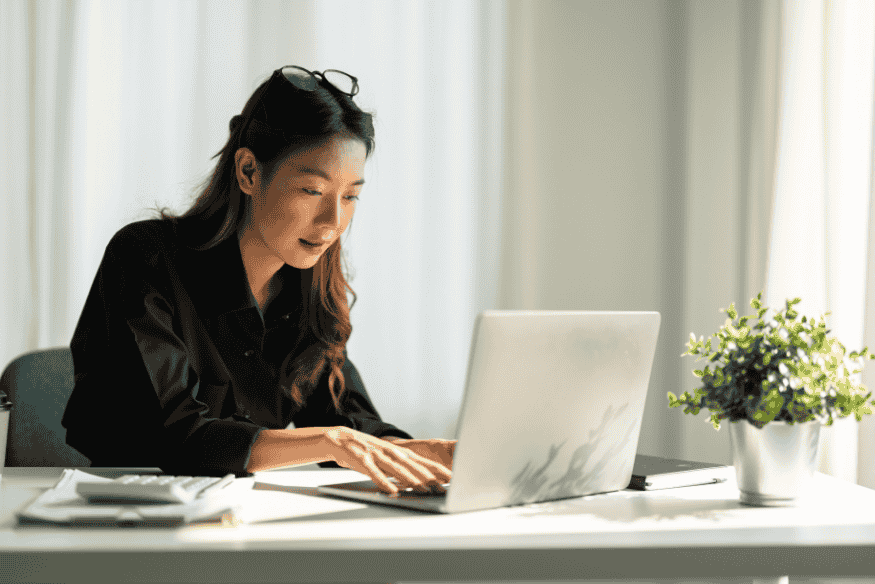 Mulher analisando finanças no computador para sair do crédito rotativo do cartão de crédito