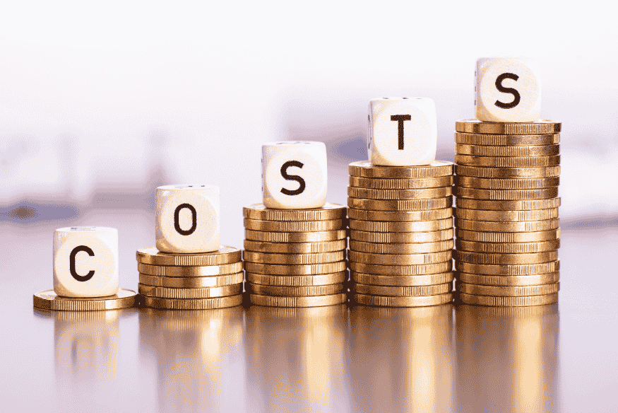 Pilhas de moedas em crescimento com dados formando a palavra "COSTS", representando o aumento do Custo Efetivo Total (CET) com a inclusão de seguros em operações de crédito.