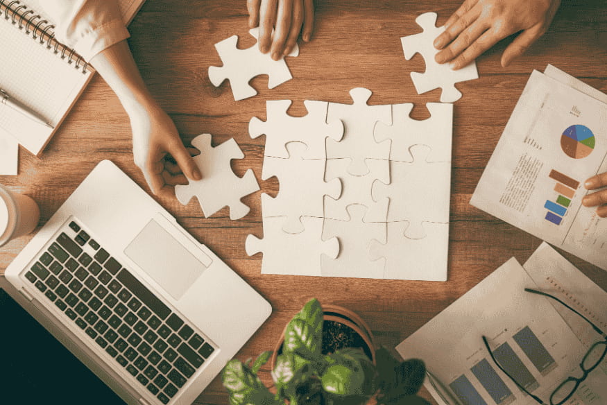 Estratégias para negociar ou obter isenção da anuidade do cartão de crédito representadas por pessoas montando peças de quebra-cabeça