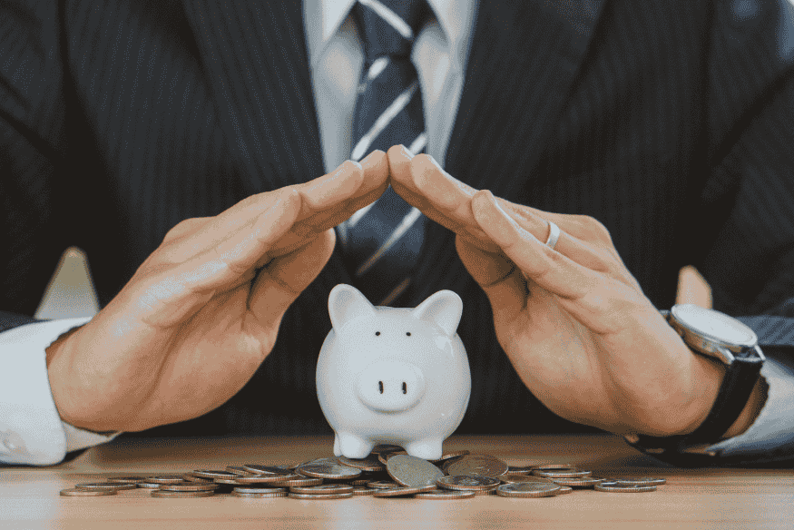 Proteção financeira simbolizada por cofre em formato de porquinho cercado por moedas, representando escolhas seguras no uso do cartão de crédito