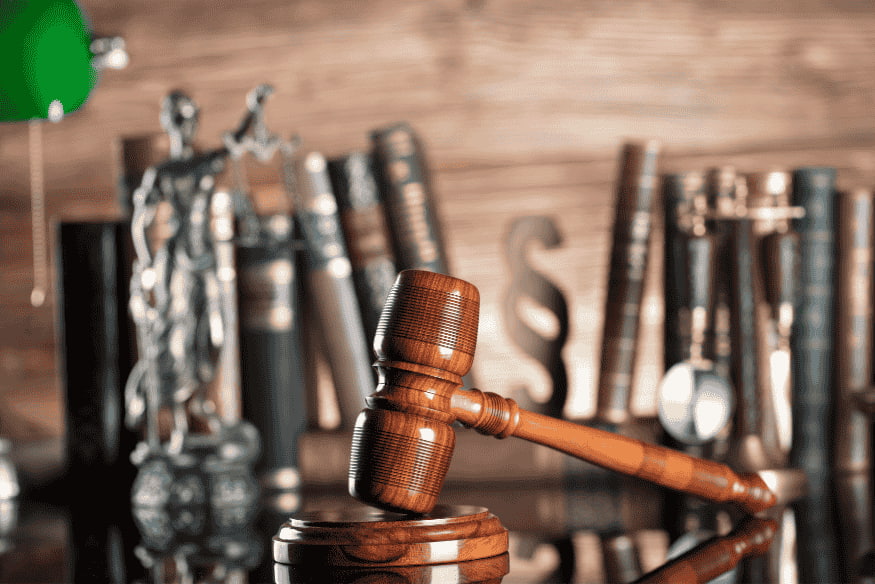 Martelo de juiz sobre mesa com livros de direito ao fundo, representando a conclusão sobre prescrição de dívidas no Brasil e seus efeitos jurídicos.