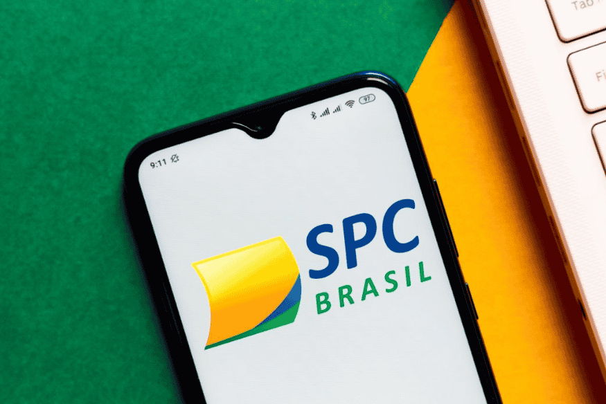 Logo do SPC Brasil exibido na tela de um smartphone, representando o Serviço de Proteção ao Crédito e sua importância no cálculo do score baseado em dados do varejo.