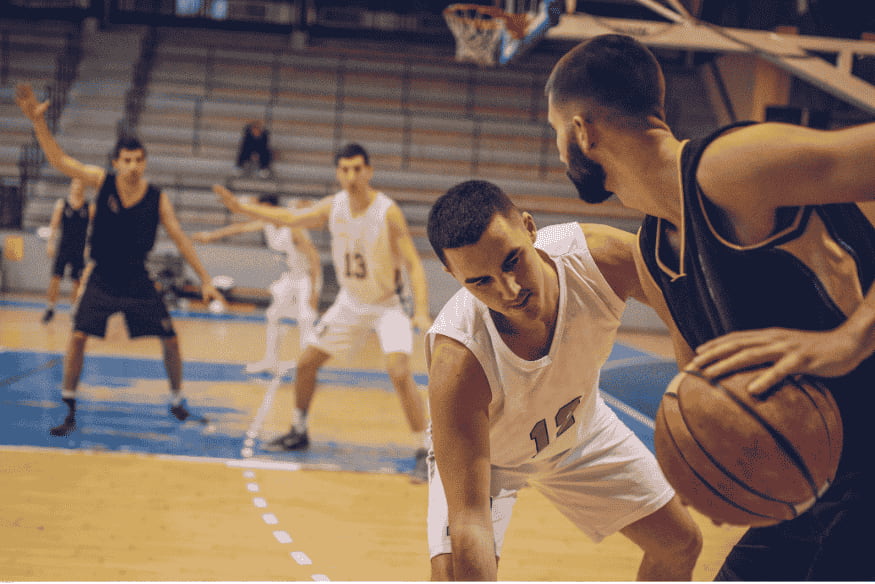 Partida de basquete 3×3 em quadra coberta, com marcação intensa entre os jogadores.