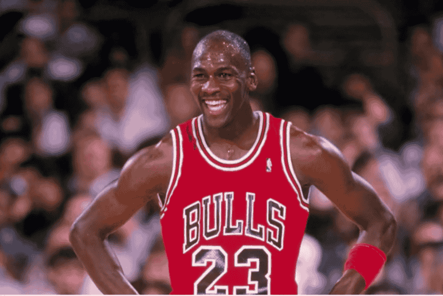 Michael Jordan sorrindo em quadra com uniforme do Chicago Bulls número 23.