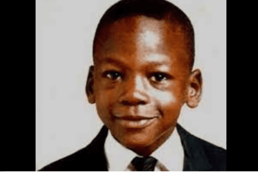 Michael Jordan criança vestindo terno e gravata em retrato escolar antigo.