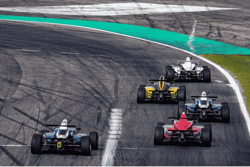 Cinco carros de Fórmula enfileirados em uma reta de circuito durante prova.