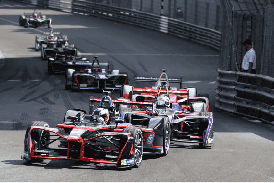 Carros de Fórmula E em uma curva de circuito urbano durante uma corrida.