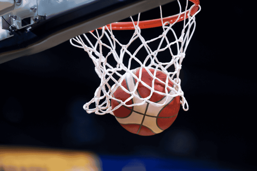 Bola de basquete passando perfeitamente pela rede da cesta durante arremesso.