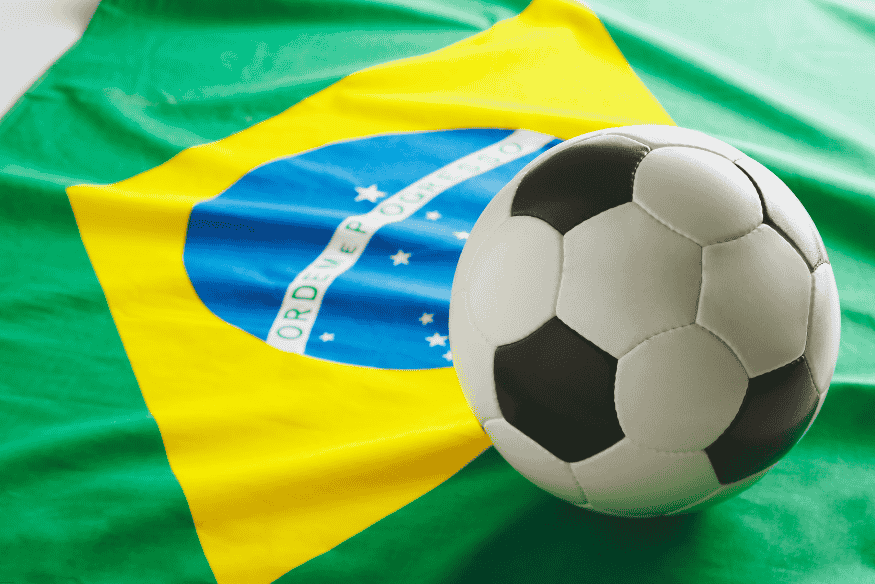 Bola de futebol sobre a bandeira do Brasil, simbolizando a relação do esporte com a identidade nacional.