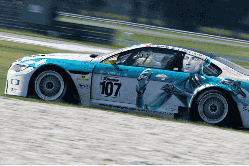 Carro de turismo decorado com arte robótica azul e número 107 competindo em pista.