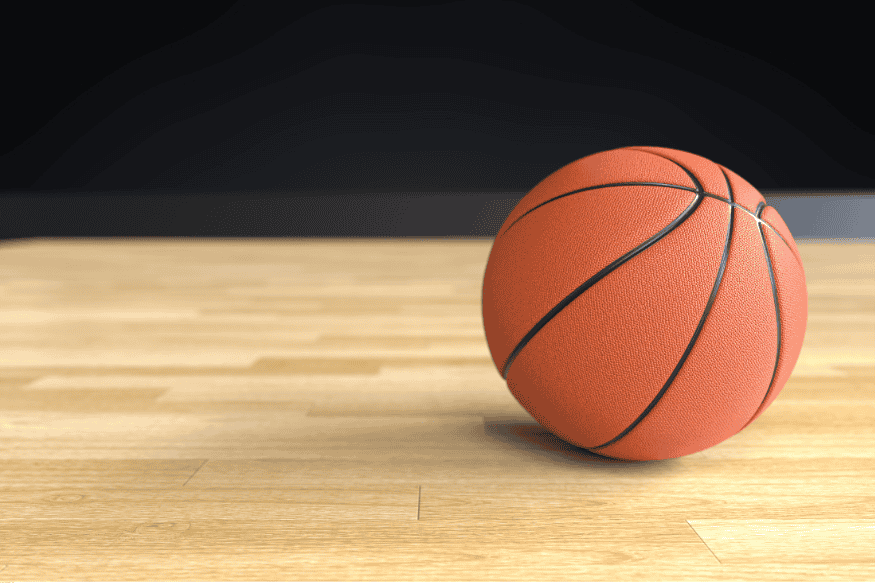 Bola de basquete sobre quadra de madeira, pronta para o início da jogada.