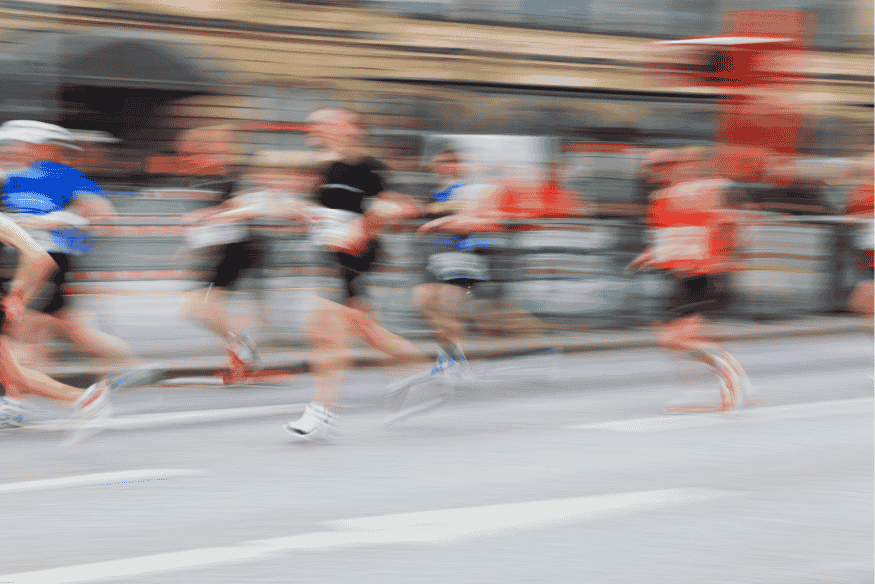 Corredores em velocidade durante uma maratona urbana, com efeito de desfoque de movimento
