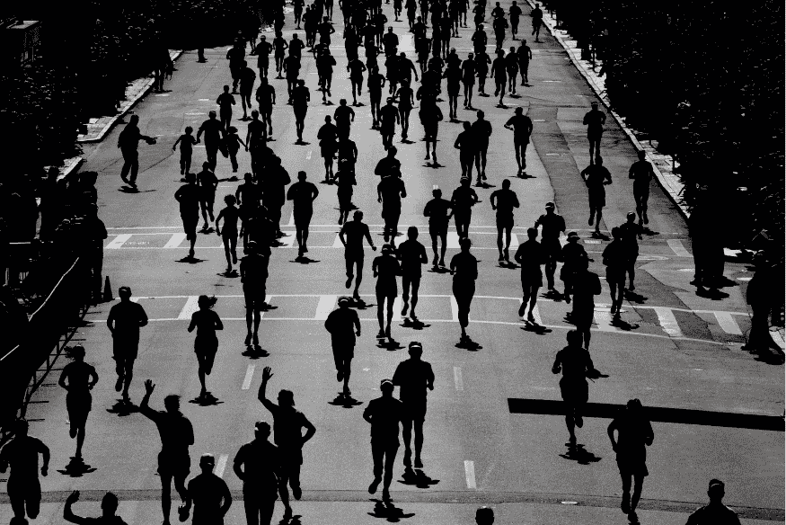Silhuetas de corredores ocupando toda a avenida durante uma grande prova de corrida urbana