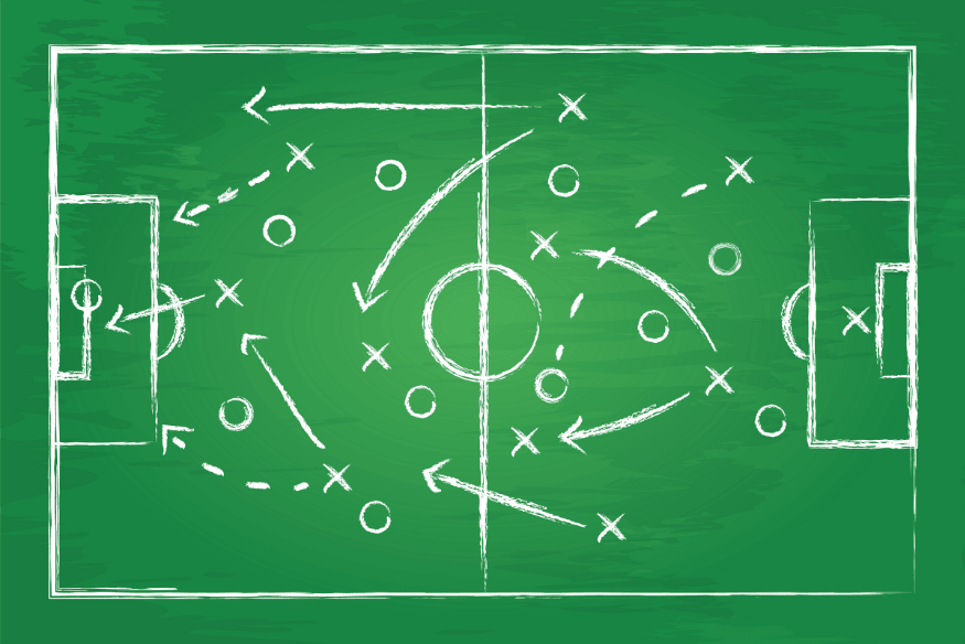 Quadro verde com desenhos táticos simulando movimentações e estratégias de jogo.