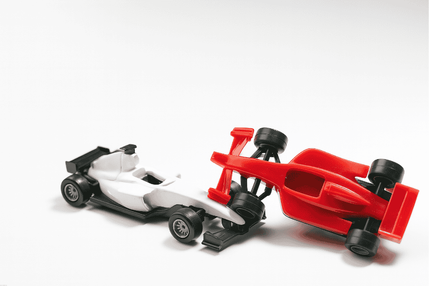 Dois carros de Fórmula 1 de brinquedo colidem em uma simulação de acidente.