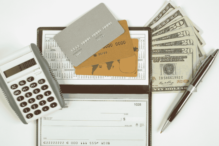 Cartões de crédito, cheques, dinheiro e calculadora, simbolizando o uso consciente de crédito para gestão financeira.
