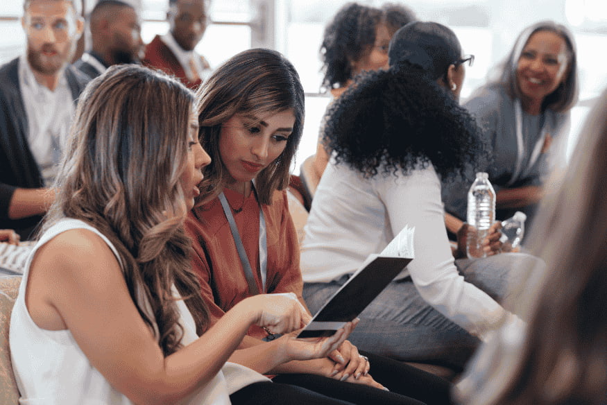 Grupo de pessoas em evento discutindo informações financeiras, representando os feirões de renegociação organizados por instituições como Serasa e bancos.