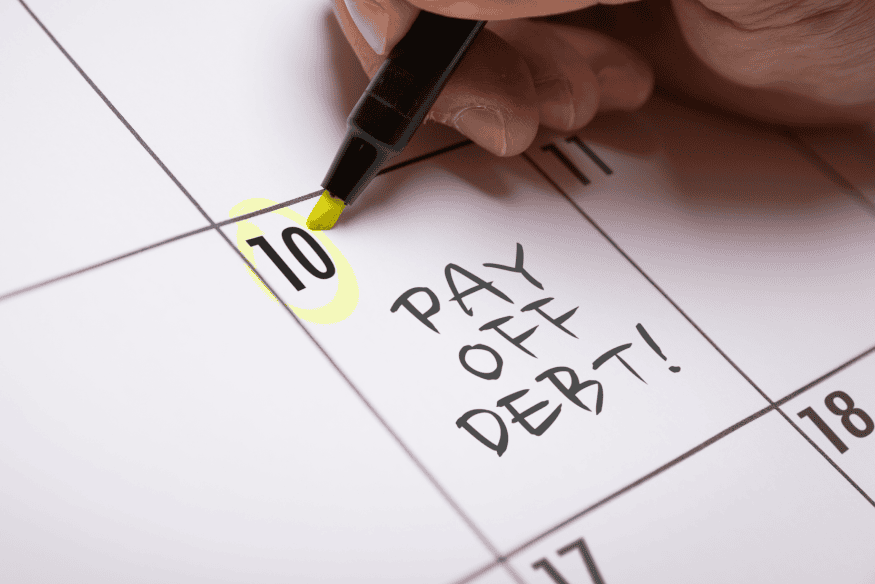 Calendário marcado com a frase “Pay Off Debt” e data destacada, simbolizando o planejamento para aproveitar feirões de renegociação de dívidas.