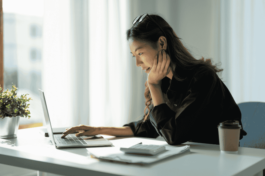 Mulher usando notebook em ambiente de trabalho, simbolizando a praticidade e segurança de negociar dívidas online com desconto.