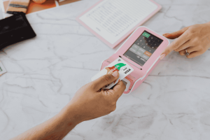 Cartão inserido em terminal de pagamento durante compra presencial, representando comparação entre cartão por aproximação e Pix por aproximação.